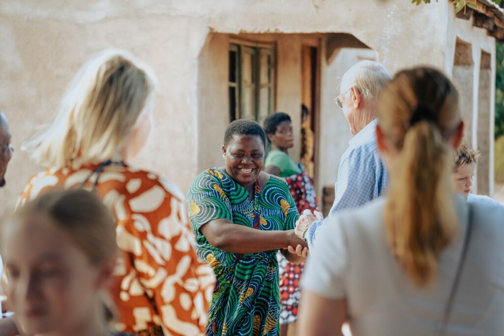 Edrina speaking to Hunger Project visitors outside her home in Kandusiwa village, Salima District.